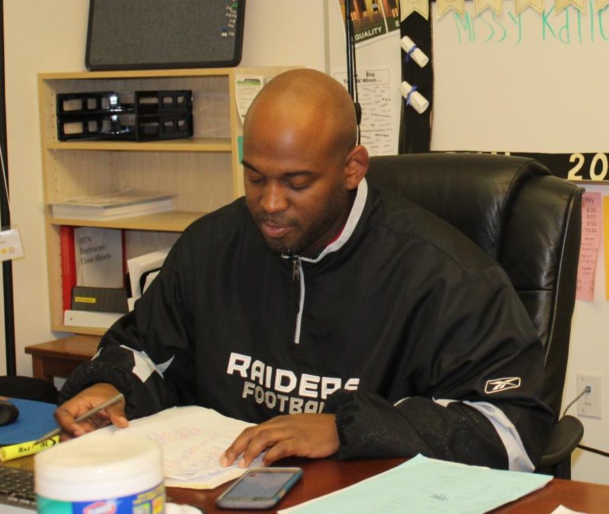 Damein Roache sits at his desk doing some paperwork. SUN offeres new after school opportunities for students.