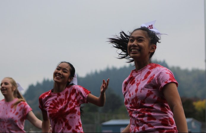 Dance team smiles during their routine in the outdoor assembly. 
