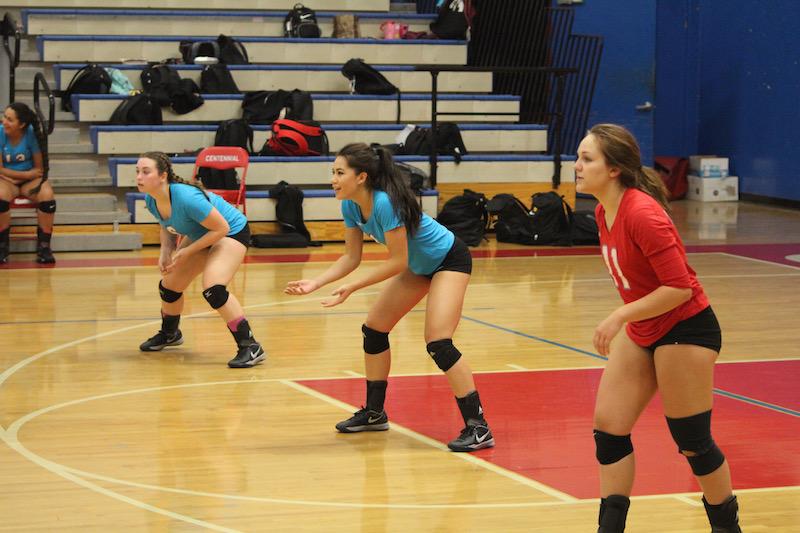 Rhyan Becker, Trina Varney, and Hannah Bowlen get ready for the ball during a home game.