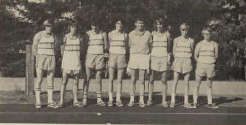 Hiram Crane (pictured in middle) stands with cross country team. Scanned from 1974 yearbook.