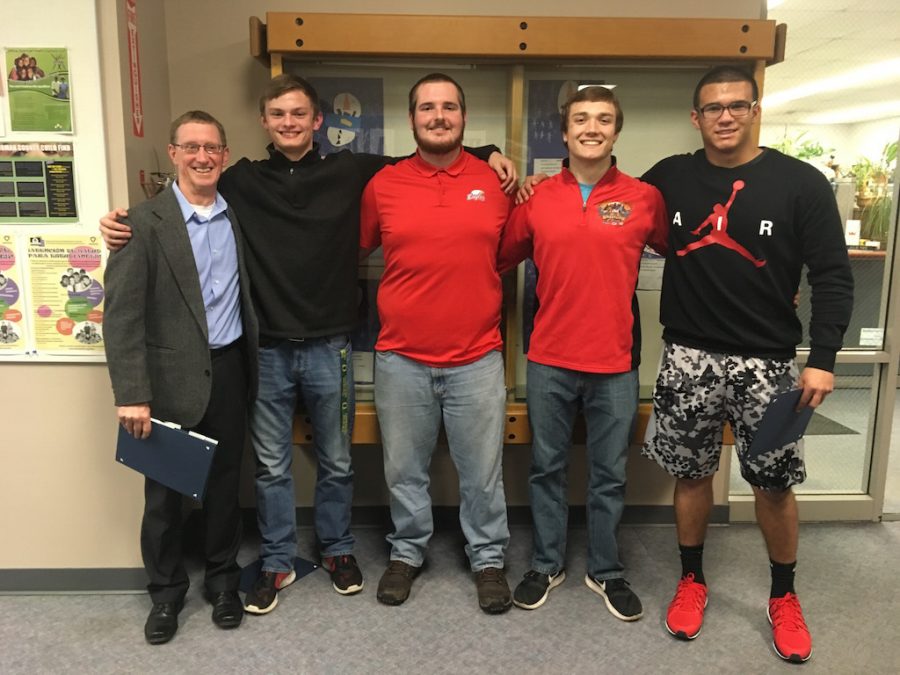 Head Football Coach Chris Knudsen received his third 6A Coach of the Year Award last fall. First team all league players  Junior Jadon Pickles, senior Nick Lyngheim, senior Henry Button and senior Tyson Regimbal were honored along with Knudsen at Wednesday's school board meeting. 