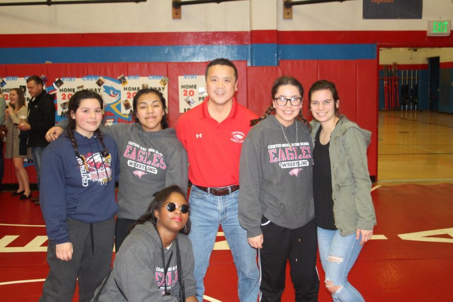 Center: Head girls wrestling coach Taz Lee and other girl wrestlers from 2017/18.