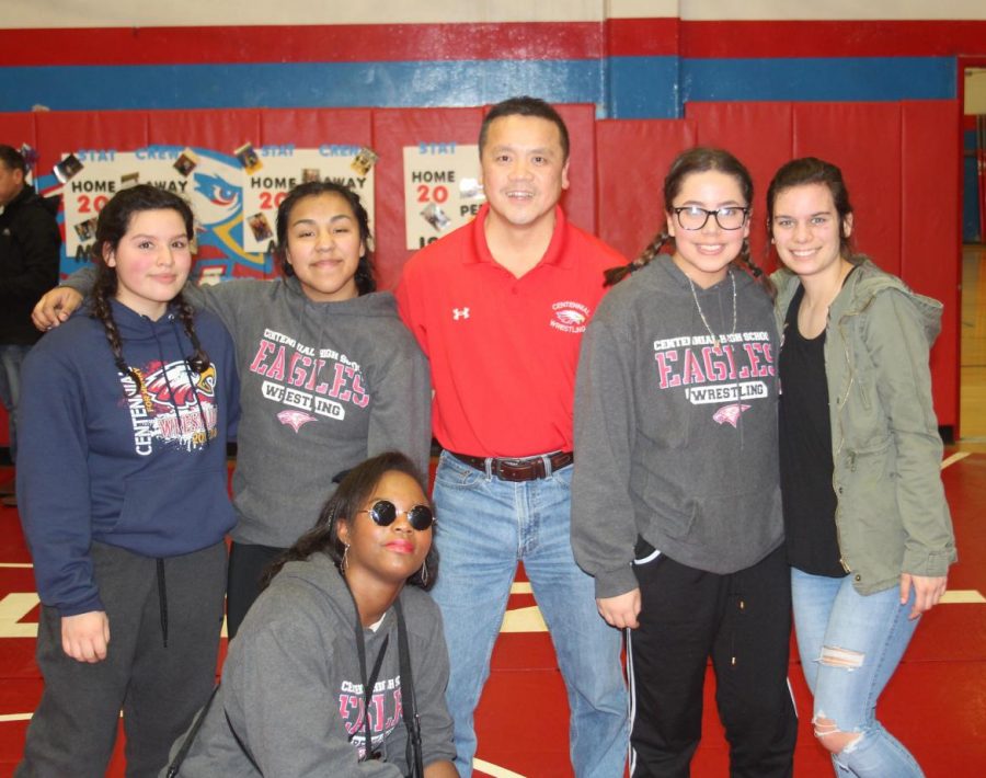 Center: Head girls wrestling coach Taz Lee and other girl wrestlers from 2017/18.